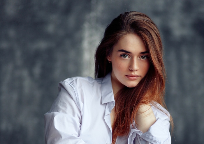 Woman in white shirt against a textured background