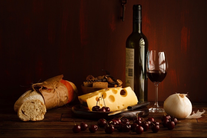 Still life with wine, cheese, bread, and cherries