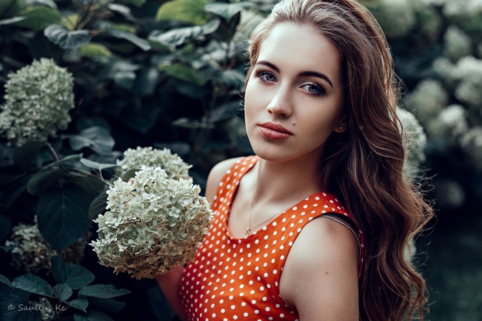Woman in red polka dot dress near hydrangeas
