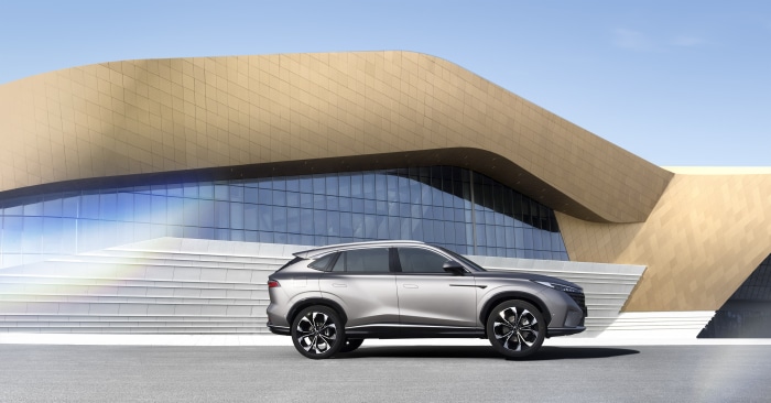 Roewe RX5 SUV parked in front of modern architecture
