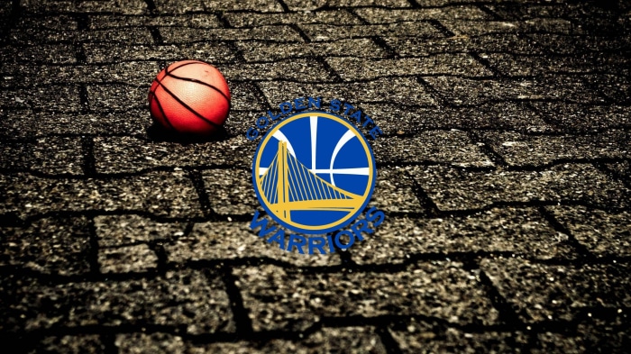 Golden State Warriors logo and basketball on asphalt
