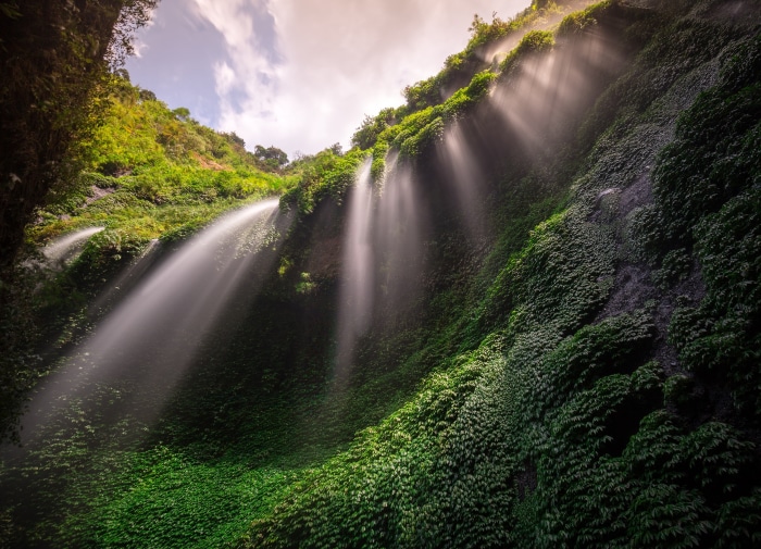 Waterfall with sunbeams through mist