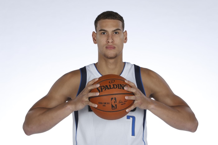 Dwight Powell holding a Spalding basketball