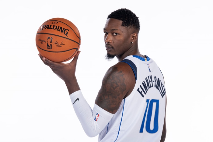 Dorian Finney-Smith holding a Spalding basketball