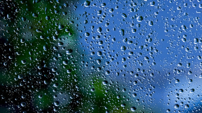 Raindrops on a window with green and blue background