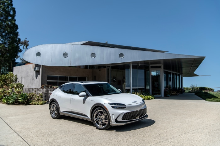 White Genesis GV60 parked in front of a modern building