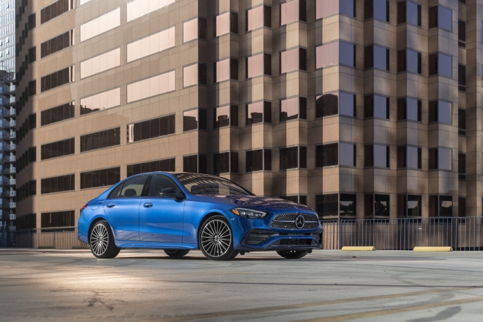 Blue Mercedes-Benz C 300 4K parked in front of a modern building