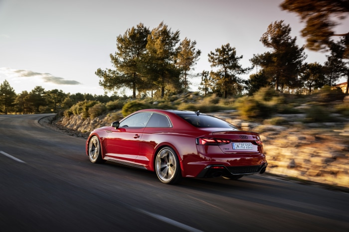 Red Audi RS5 driving on a winding road