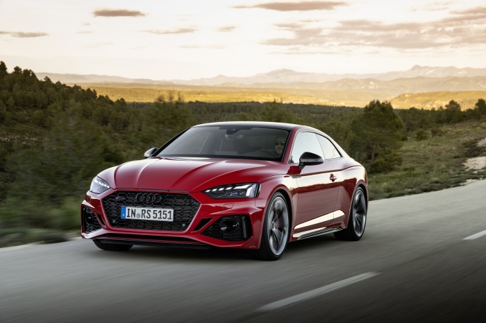 Red Audi RS5 Coupe driving on a road