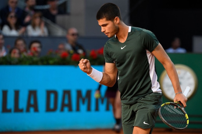 Carlos Alcaraz celebrates on a tennis court
