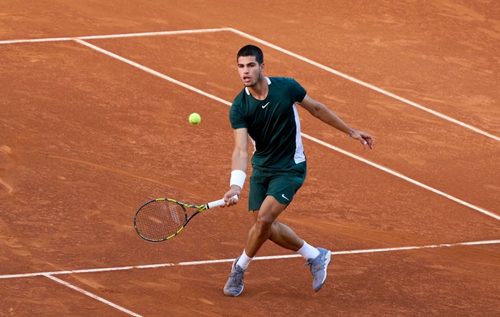 Carlos Alcaraz playing tennis on a clay court
