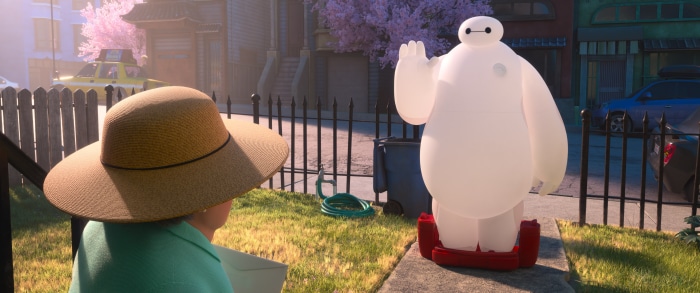 Baymax waving from a sidewalk