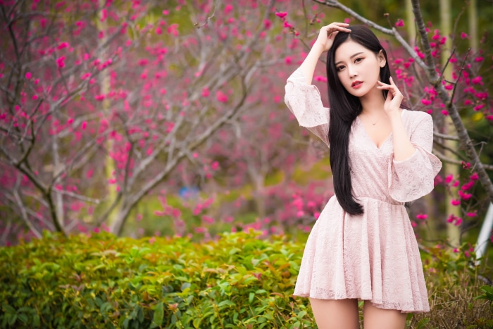 Asian woman in pink dress among pink flowers