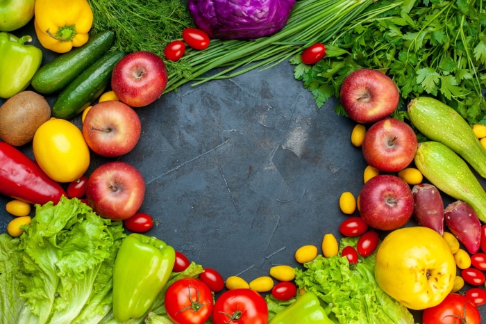 Assortment of fresh fruits and vegetables on a dark surface
