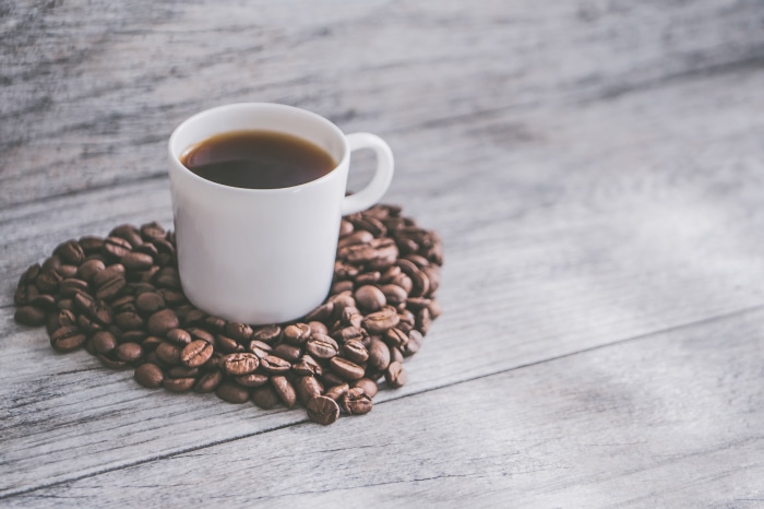 Cup of Coffee on Heart-Shaped Coffee Beans 4K