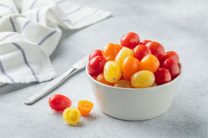 Bowl of colorful cherry tomatoes with a knife and napkin