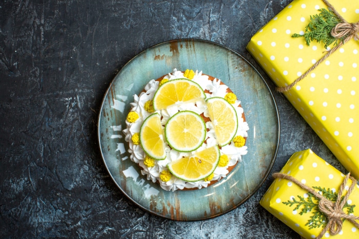 Lemon cake with whipped cream and lime slices on a plate