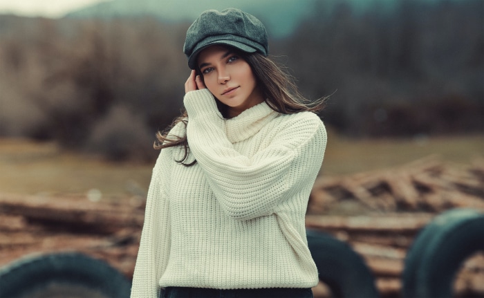 Woman wearing a sweater and cap outdoors