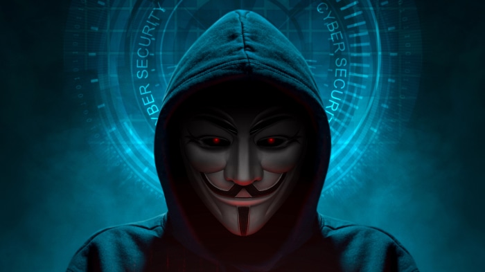 Anonymous hacker in a hoodie with red eyes