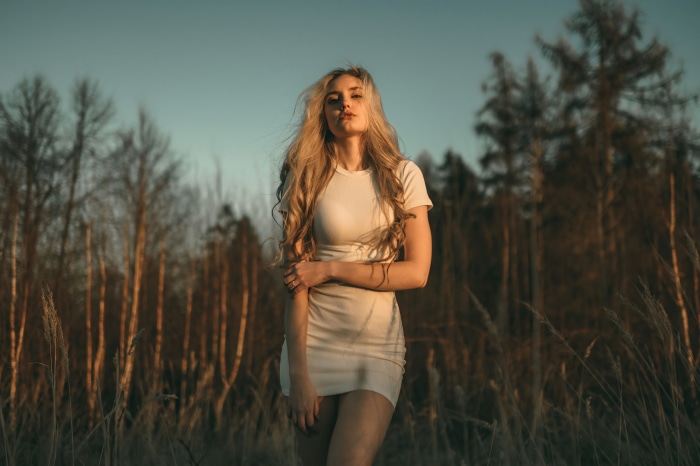Blonde woman in white dress in field