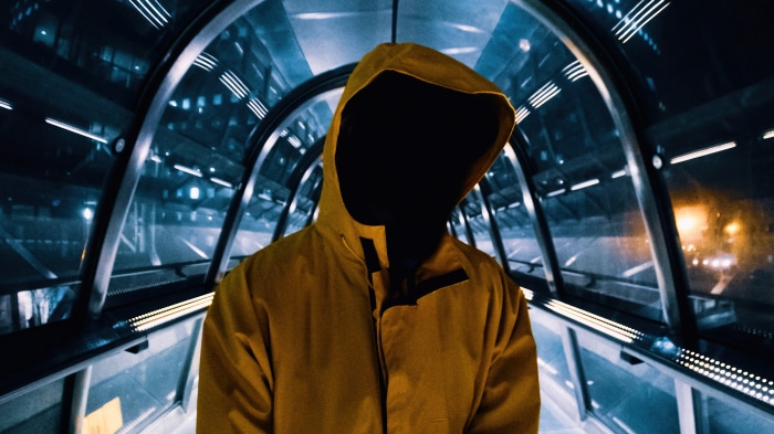 Person in yellow hoodie in futuristic tunnel