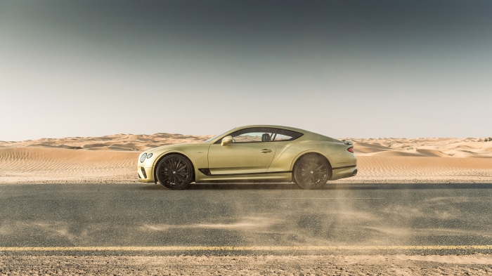 Bentley Continental GT driving through desert dunes