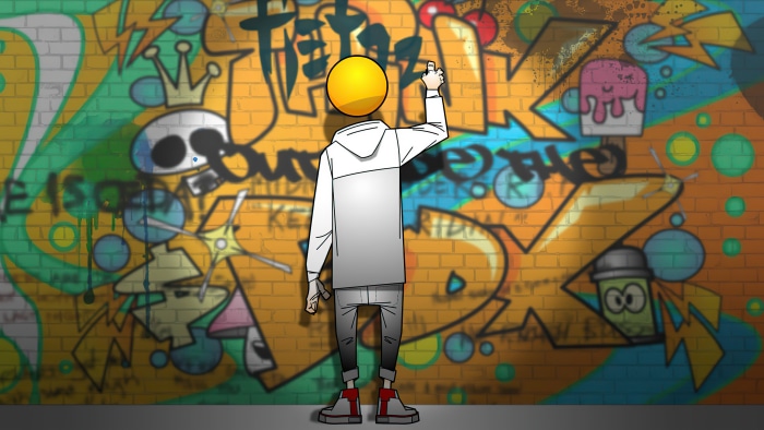 Graffiti artist with a yellow head painting on a brick wall