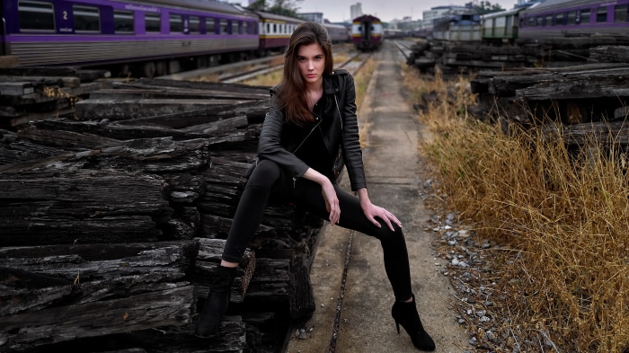 Model in black leather jacket at train station