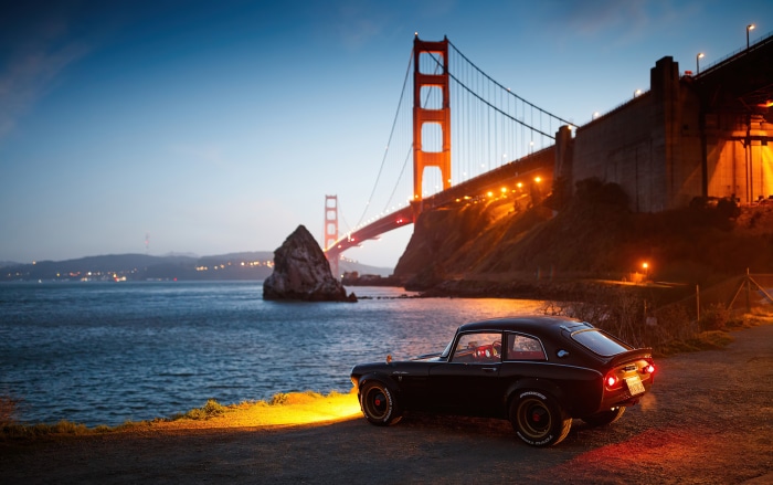 Black Honda S800 parked near Golden Gate Bridge at dusk