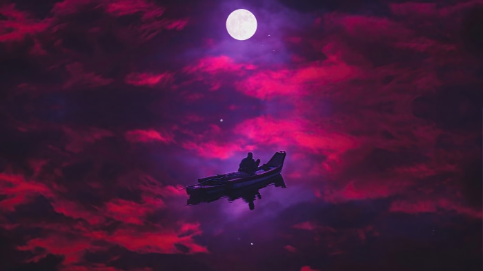 Man in a boat under a full moon and pink clouds