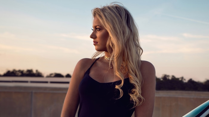 Blonde model in black dress at sunset