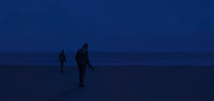 Two figures on a beach at dusk