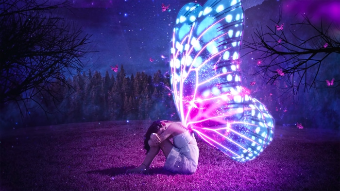 Girl with glowing butterfly wings in a magical forest