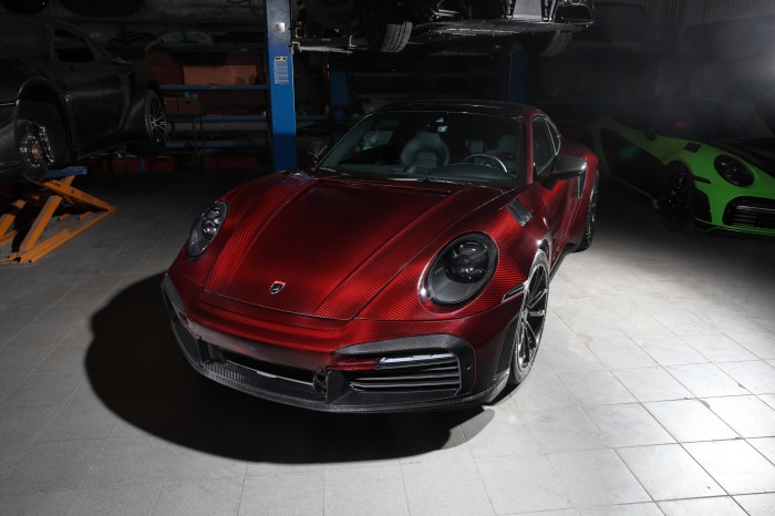 Red Porsche 911 with carbon fiber body in a garage