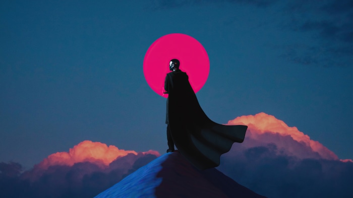 Warrior in a cape standing on a mountain under a pink sun