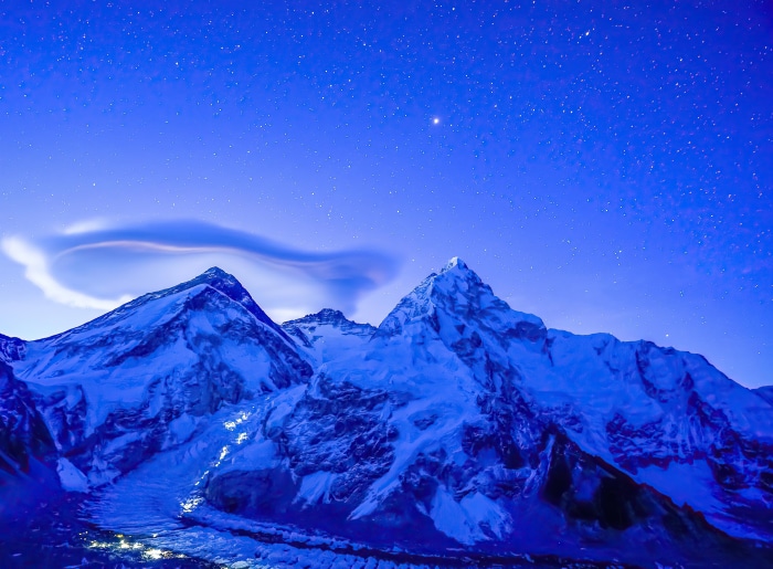 Mount Everest under starry sky with lenticular cloud
