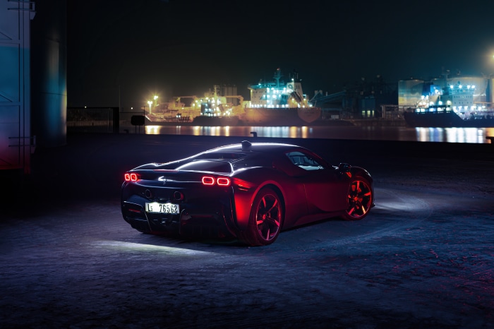 Ferrari SF90 Stradale at night with ships in background