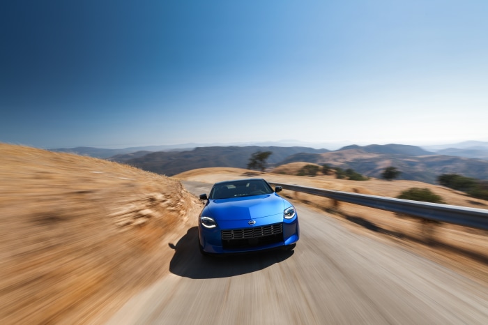 Blue 2023 Nissan Z driving on a mountain road