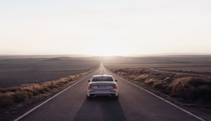 White Volvo S60 Driving on Open Road at Sunset