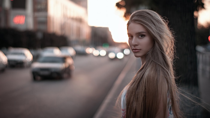Blonde girl on a city street with cars