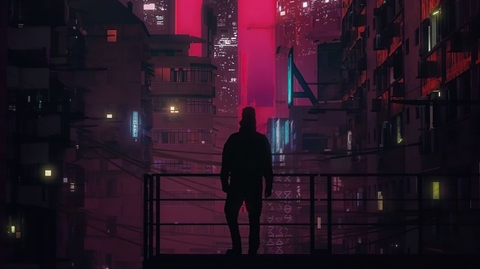 Silhouette of a person overlooking a neon city at night