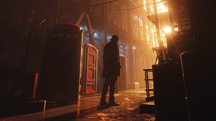 Man standing in alley with portable toilets and bright lights