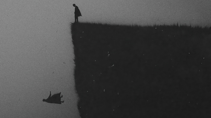 Man on cliff edge with reflection falling
