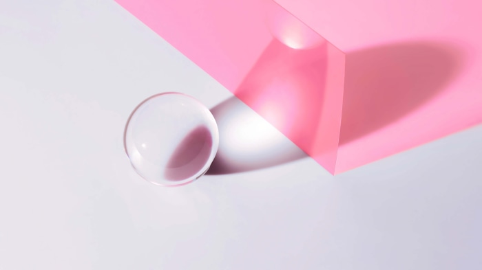 Abstract composition with pink geometric shape and glass sphere