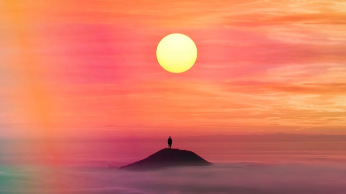 Silhouette of a person on a hill at sunset