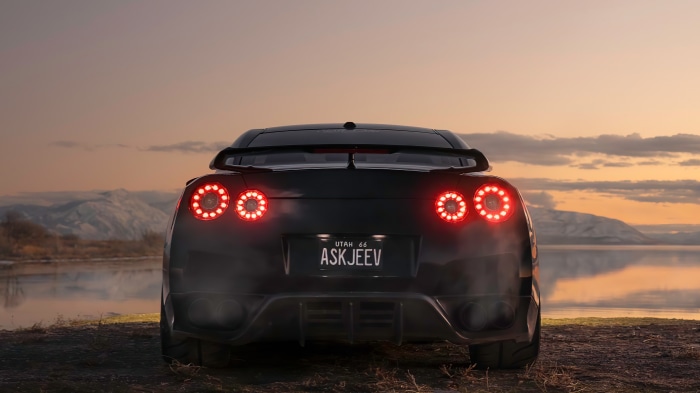 Black Nissan GT-R with custom license plate at sunset