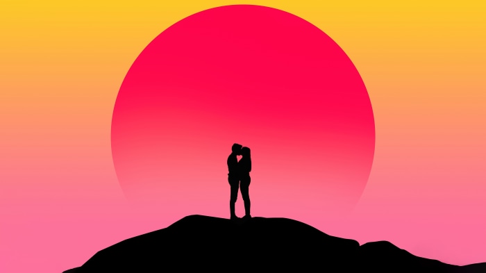 Couple kissing on a hill at sunset
