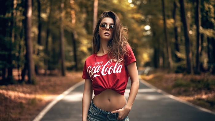 Woman in Coca-Cola shirt on forest road