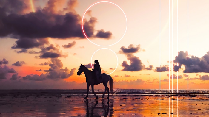 Horse rider silhouetted against a sunset with neon circles
