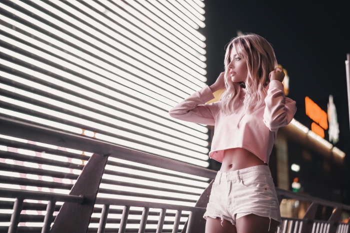 Woman in pink crop top and denim shorts at night